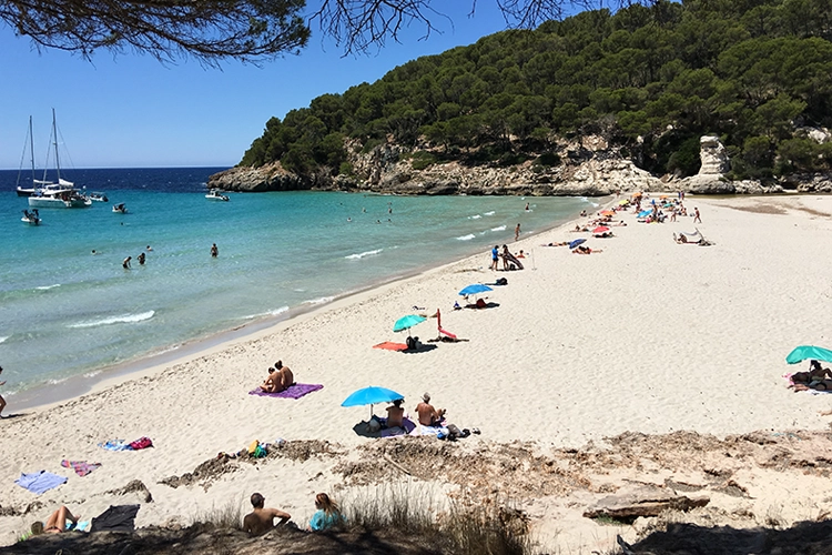 A view looking back at a quiet Cala Trebalúger beach